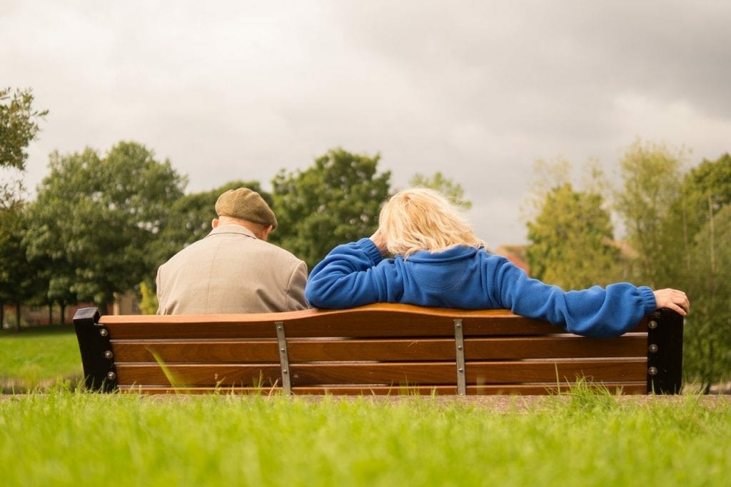 Retirees on a bench thinking of a care home