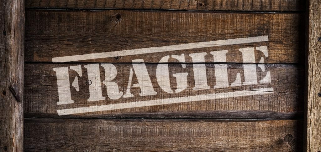 Wooden crate with the word "fragile" stenciled in white across the front, ideal for storing.