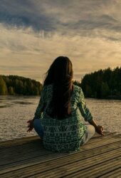 Mindfulness in action woman by lake meditating