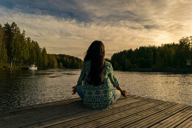 Mindfulness in action woman by lake meditating