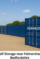 “Blue Storing.com self-storage containers near Felmersham, Bedfordshire with countryside backdrop and secure gated access”