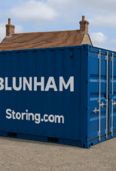 A large blue shipping container labeled "BLUNHAM" and "Storing.com" is placed in an outdoor area with a house in the background.